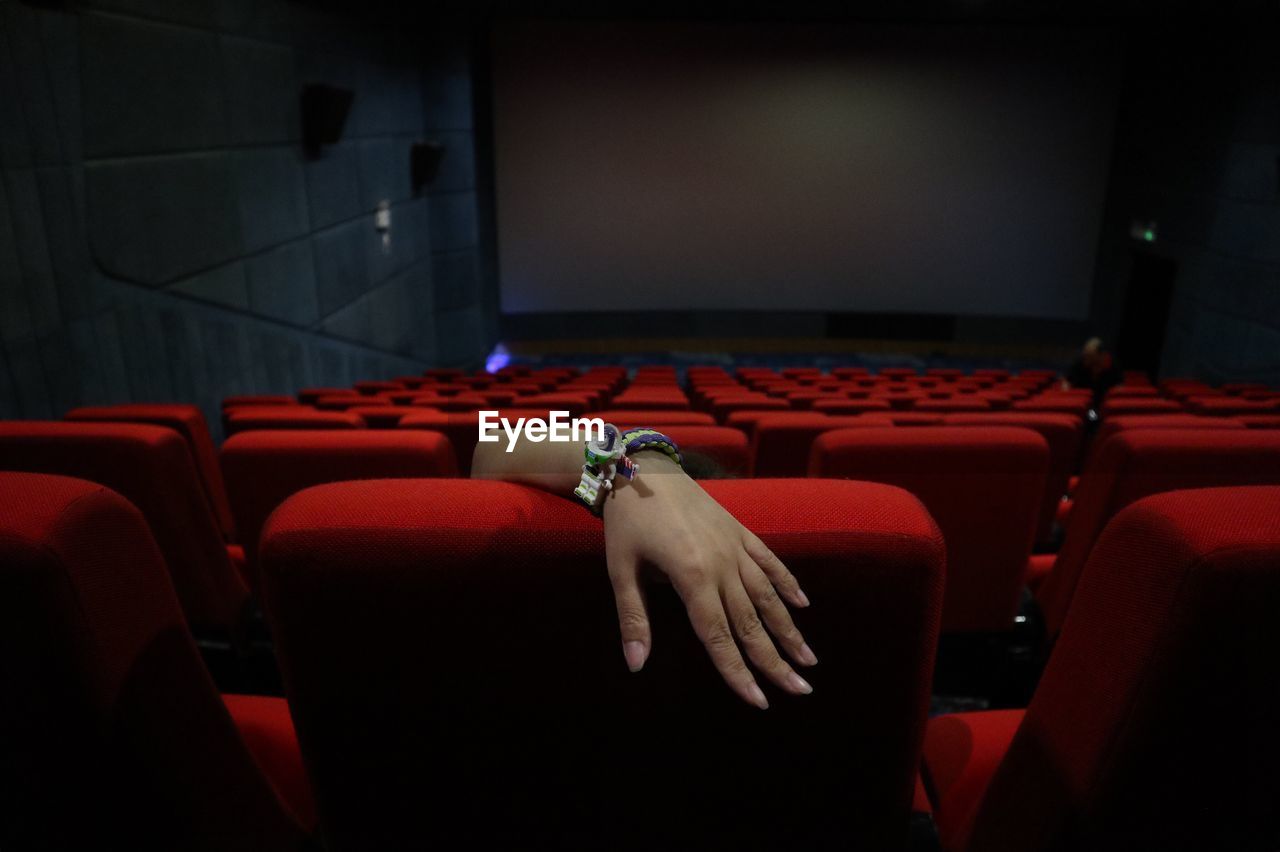 Cropped hand watching movie in theater