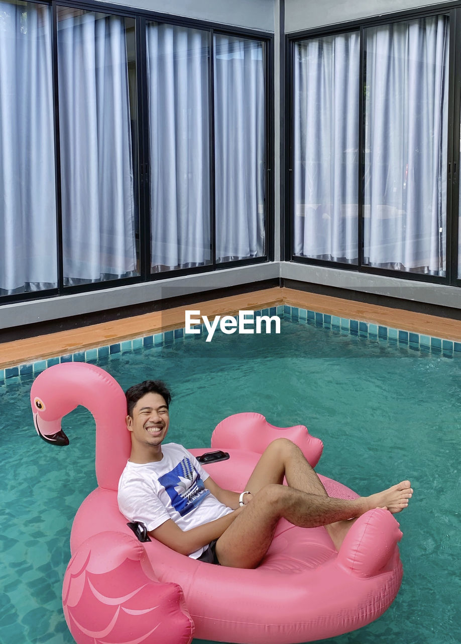 Portrait of shirtless boy swimming in pool