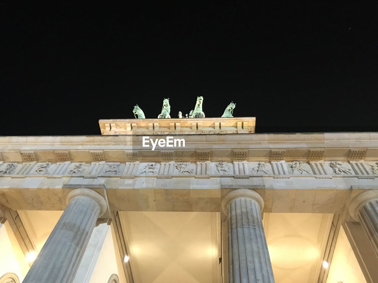 Low angle view of illuminated brandenburg gate against clear sky at night