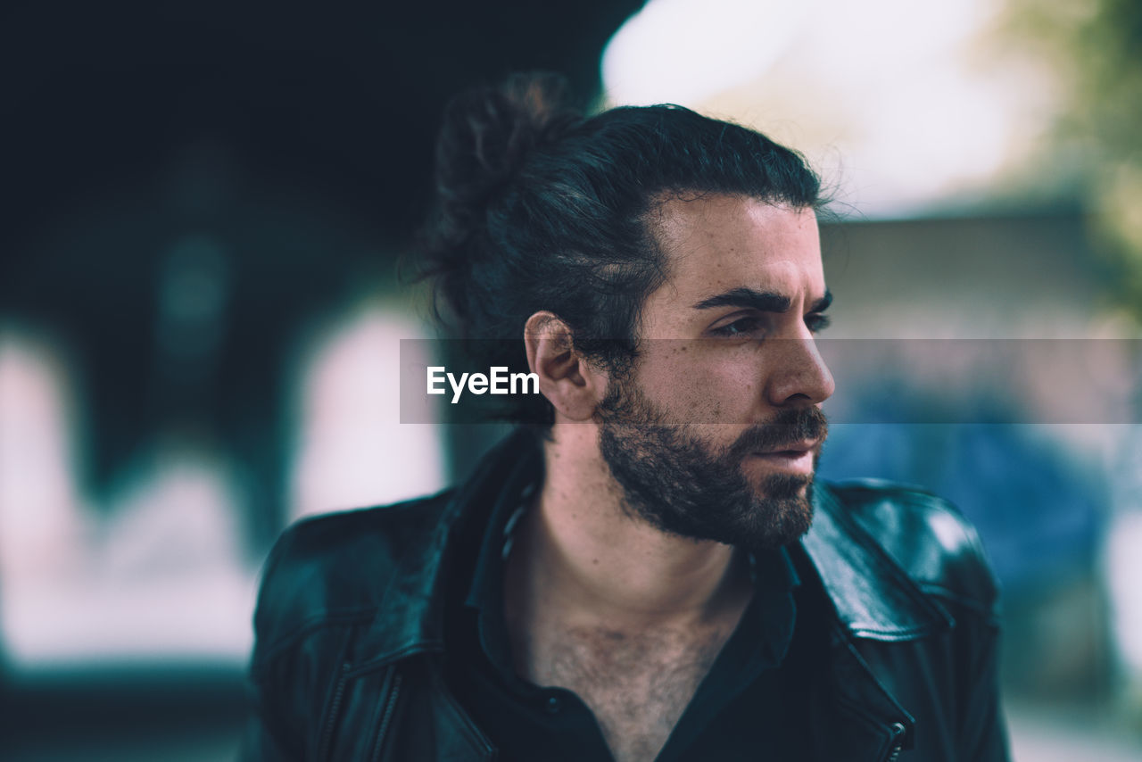 Close-up of bearded young man looking away outdoors