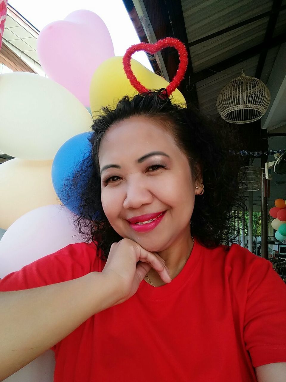 Portrait of happy woman with colorful balloons heart shape