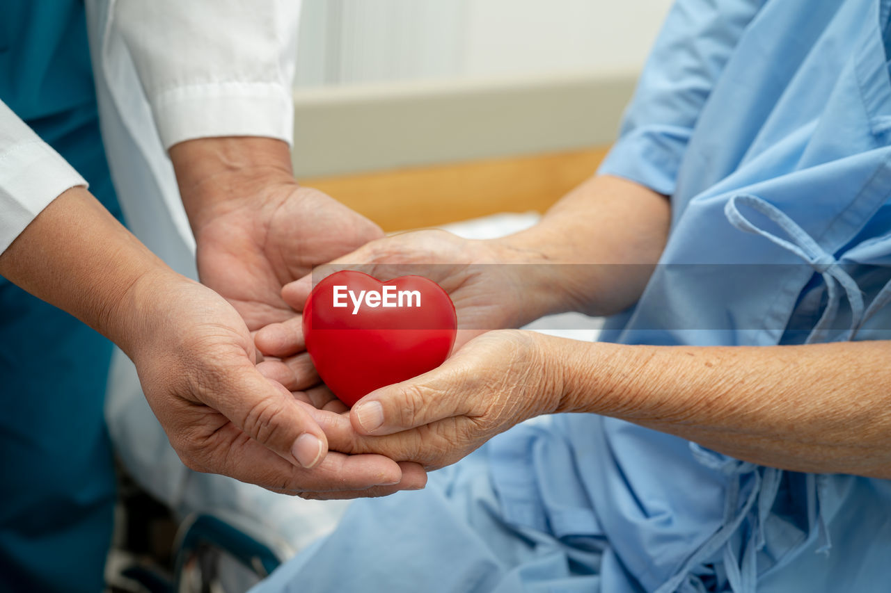 Doctor give red heart to asian senior or elderly old lady woman patient 