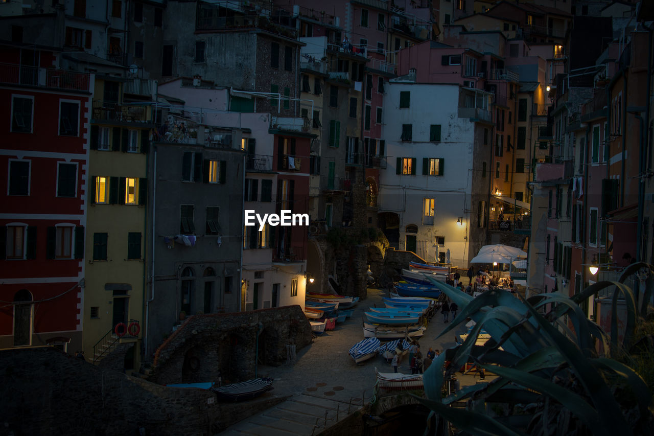 STREET AMIDST BUILDINGS IN CITY AT NIGHT