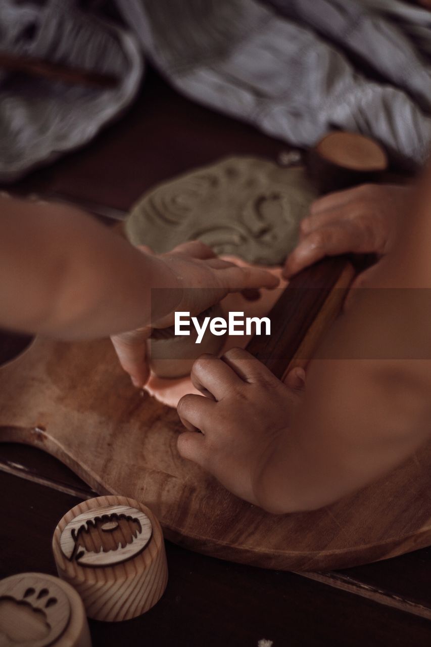 cropped hand of woman using mobile phone on bed