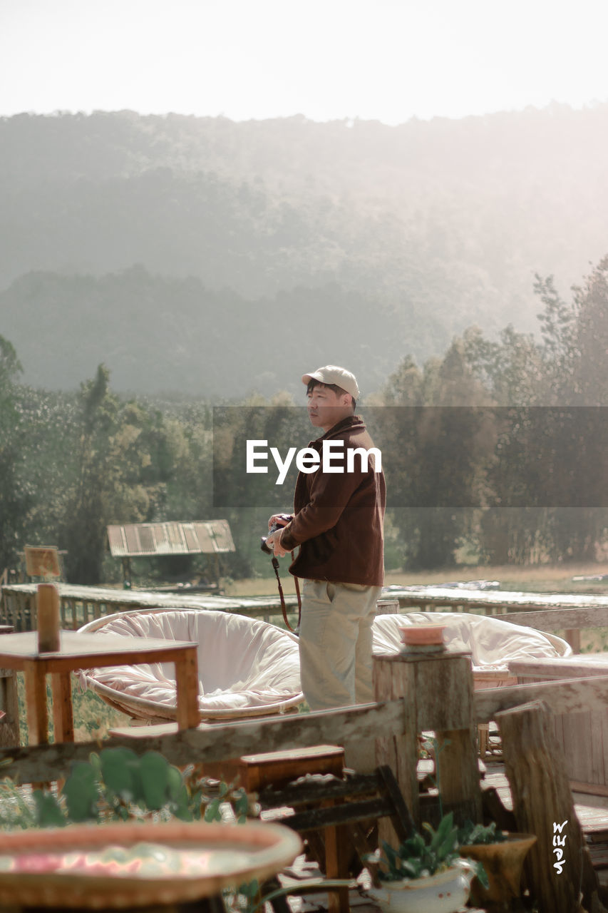 Asian man standing on beautiful terrace and beautiful view of rural resorts in thailand northeast