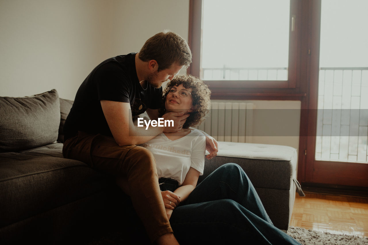 MEN SITTING ON SOFA AT HOME