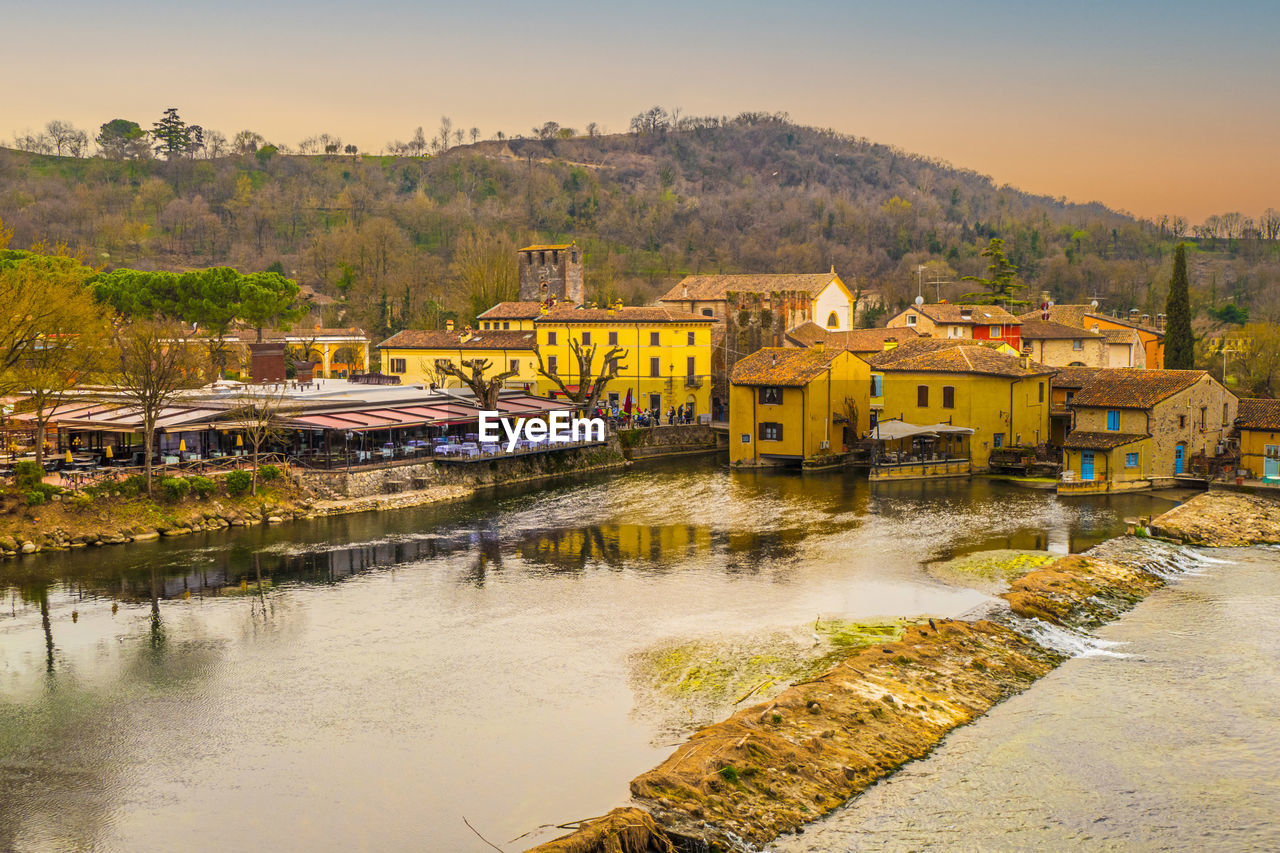 High angle view of borghetto sul mincio with the buildings reflecting on the water at sunset
