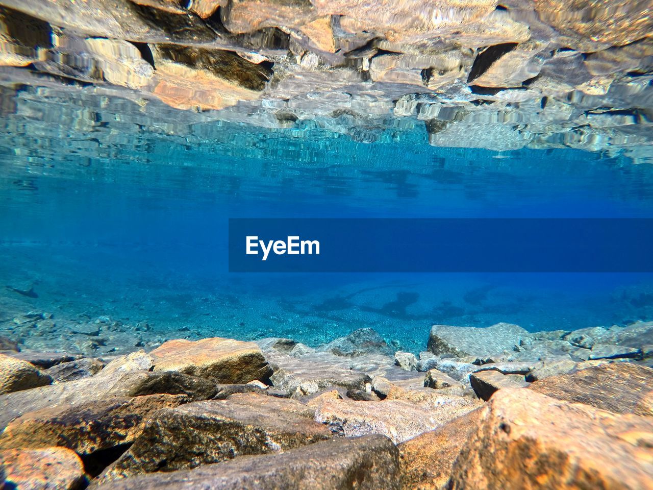 Digital composite image of rocks and blue water