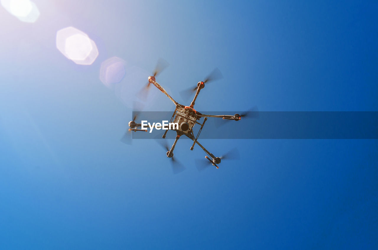 Agricultural drone in flight on a background of blue sky. field spraying new technologies.