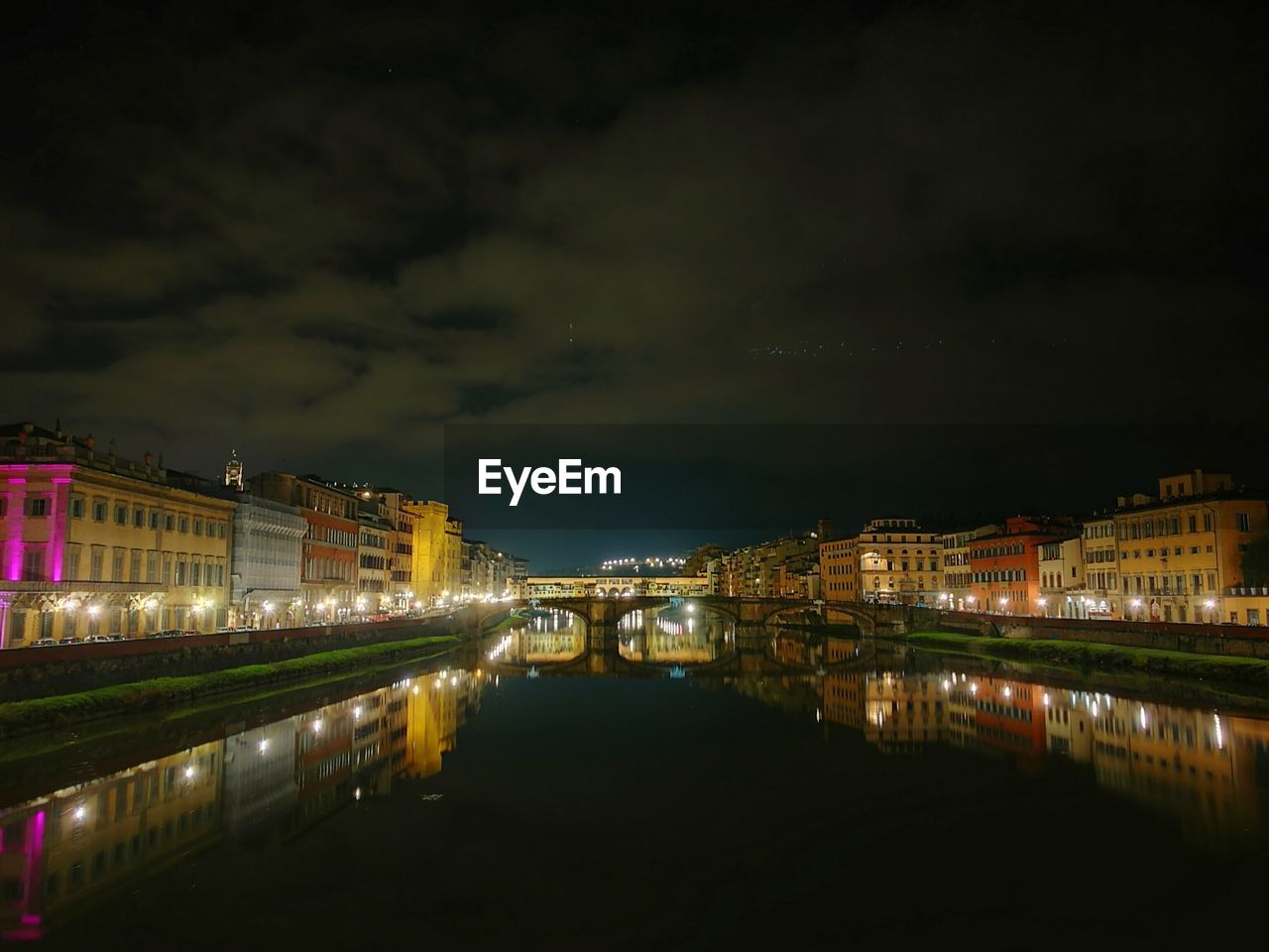 ILLUMINATED BRIDGE OVER RIVER IN CITY