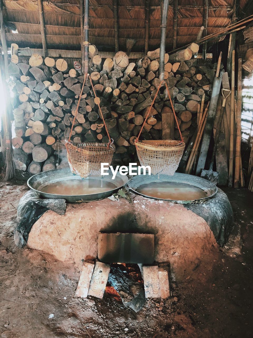 STACK OF FIREWOOD IN WICKER BASKET ON LOG