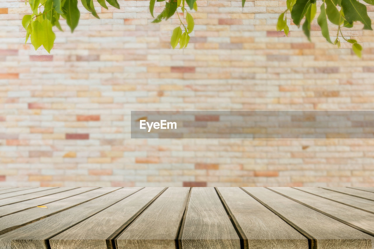 Close-up of table against brick wall