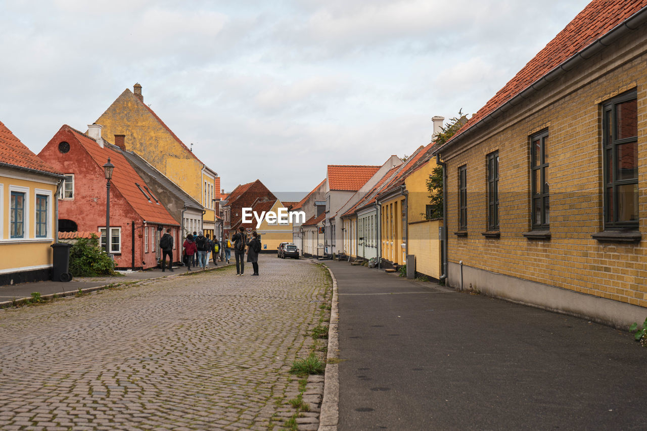 Street amidst buildings in town against sky