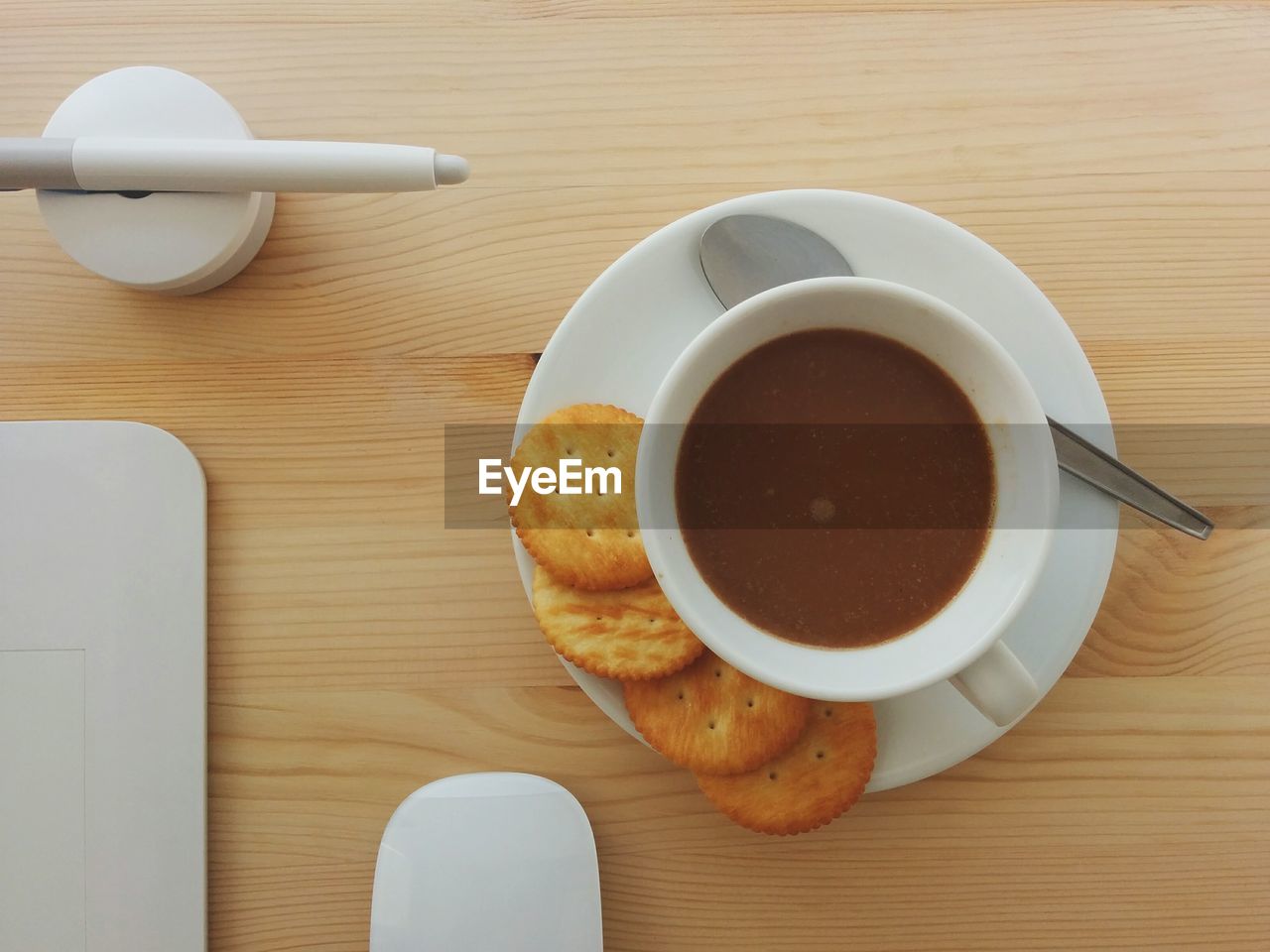 Directly above view of coffee with biscuits in saucer on table