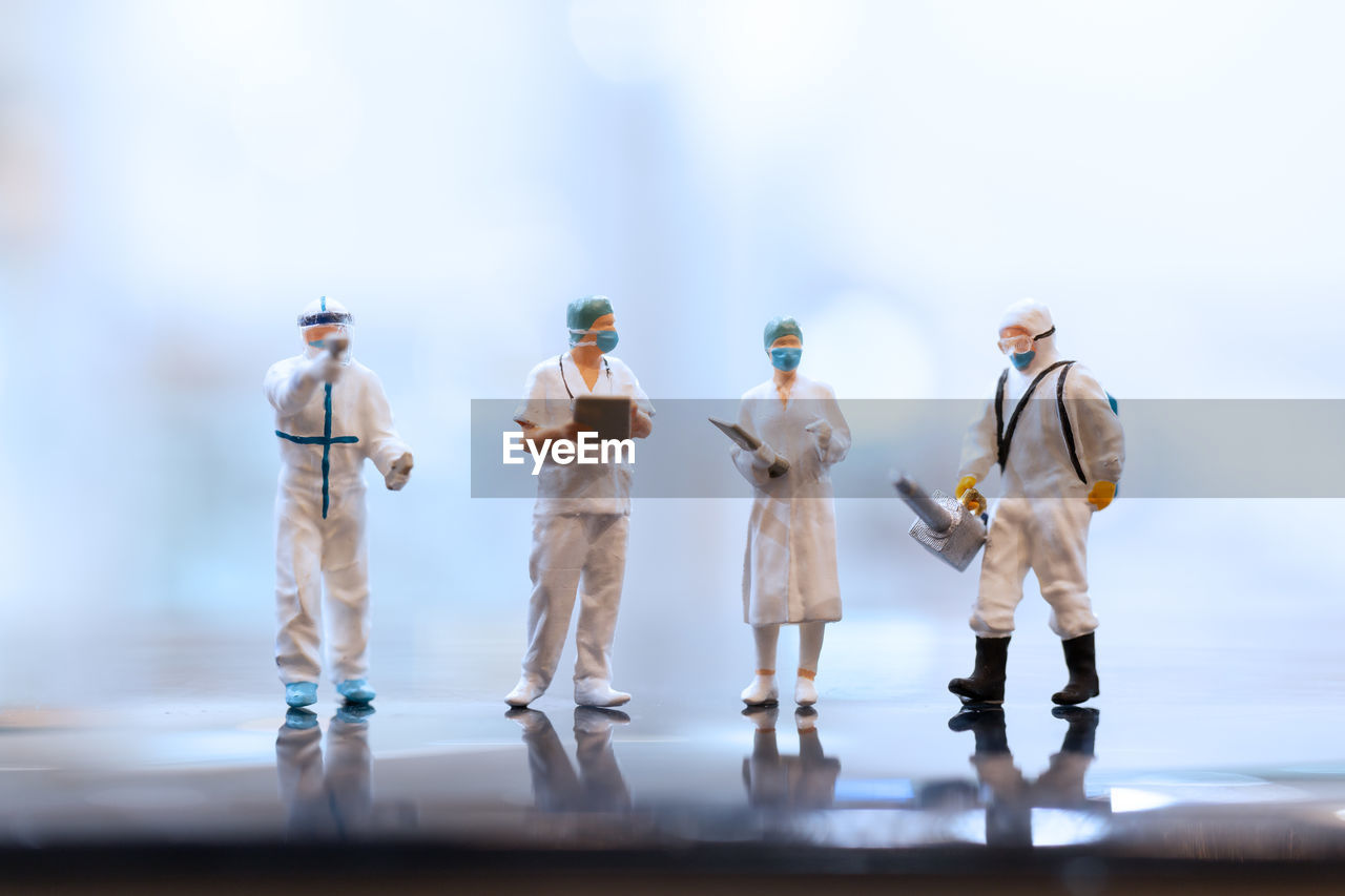 Miniature people doctor wearing face-masks during coronavirus and flu outbreak