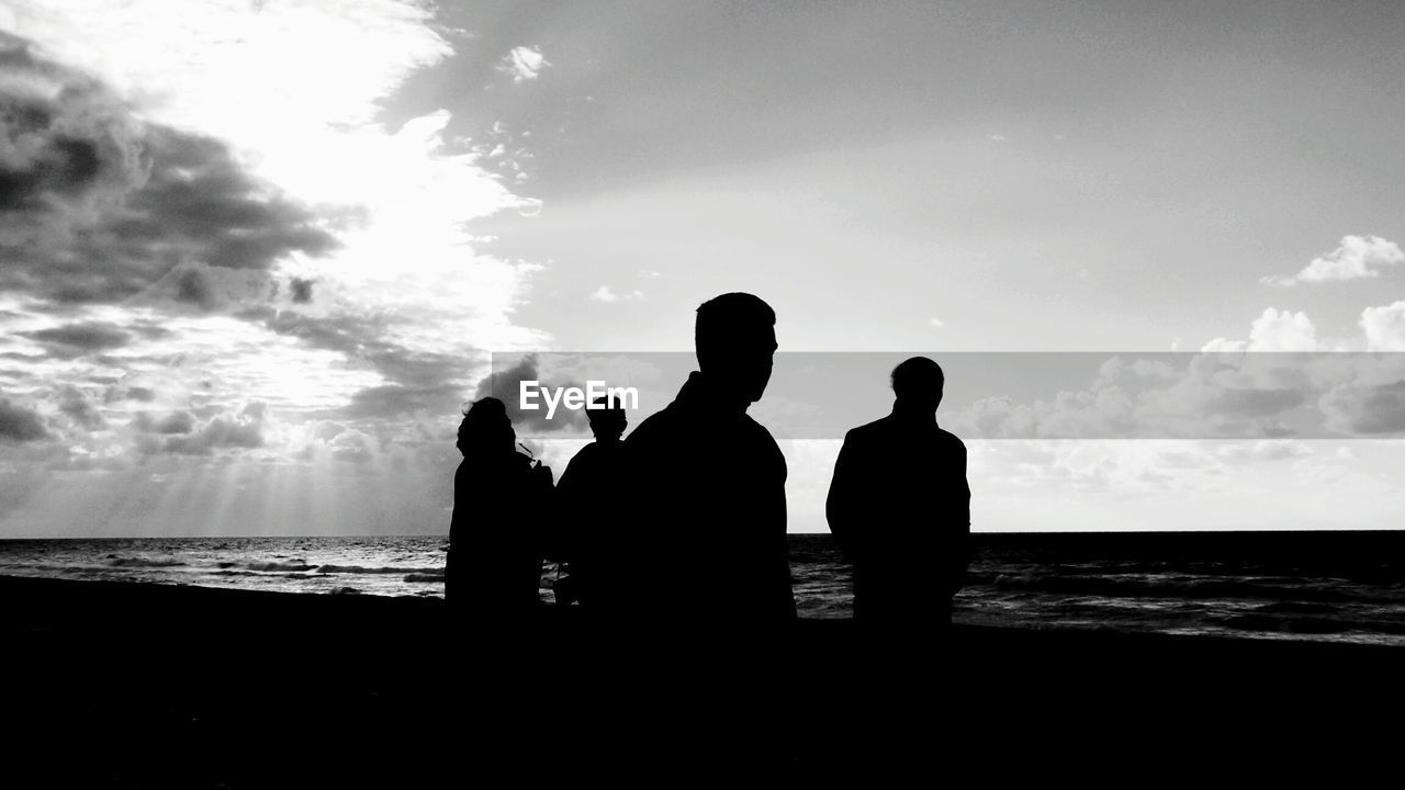 SILHOUETTE OF MEN ON BEACH