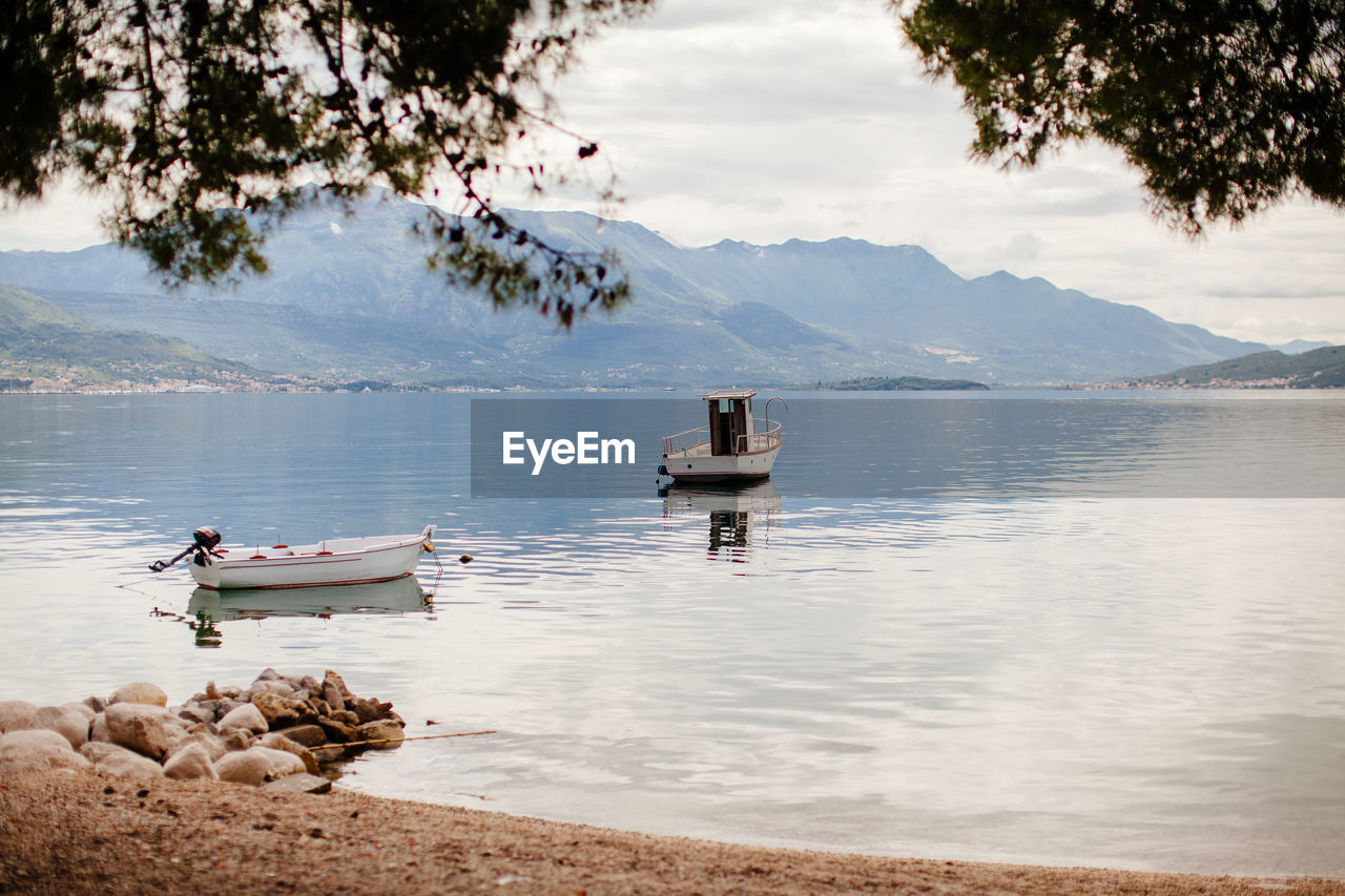 Boat moored in lake against sky