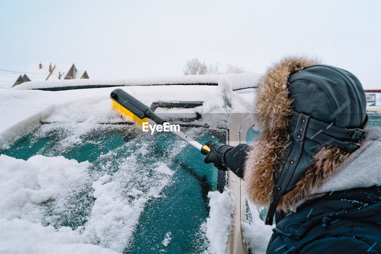 Rear view of man cleaning car