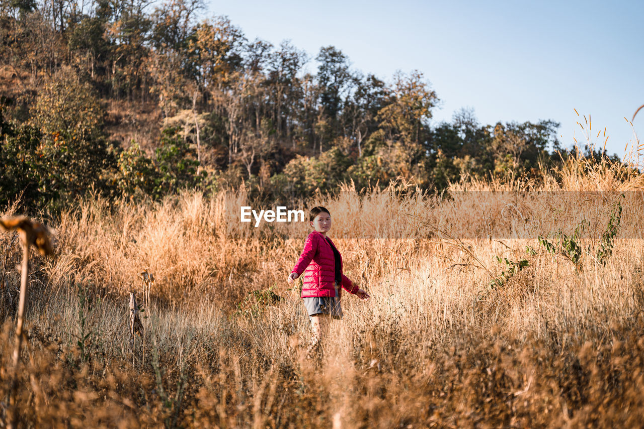 Rear view of woman walking on field