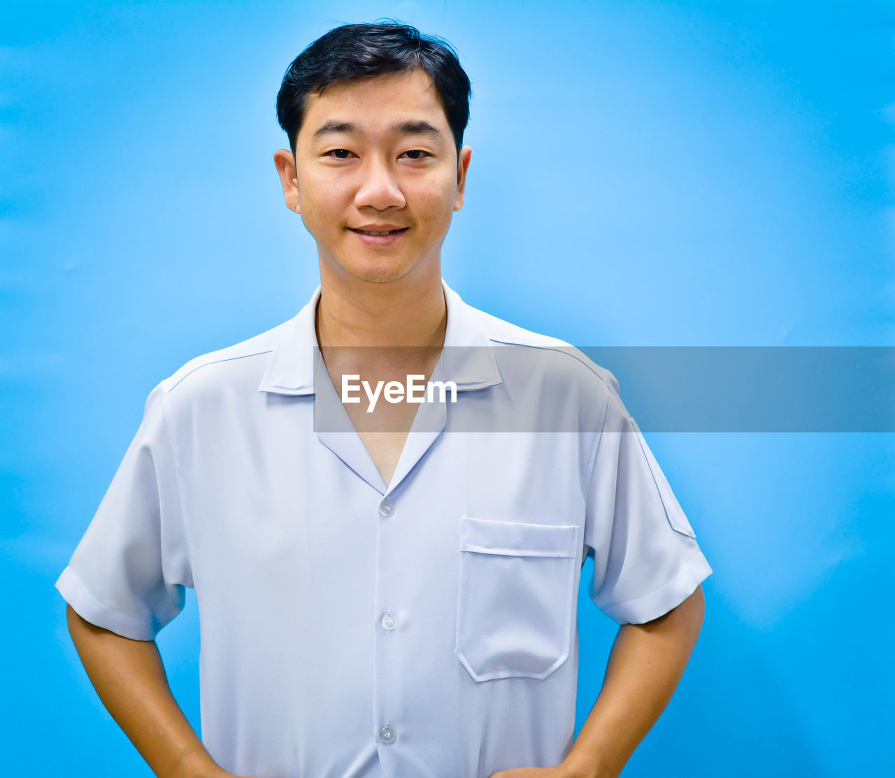 PORTRAIT OF MID ADULT MAN AGAINST BLUE BACKGROUND