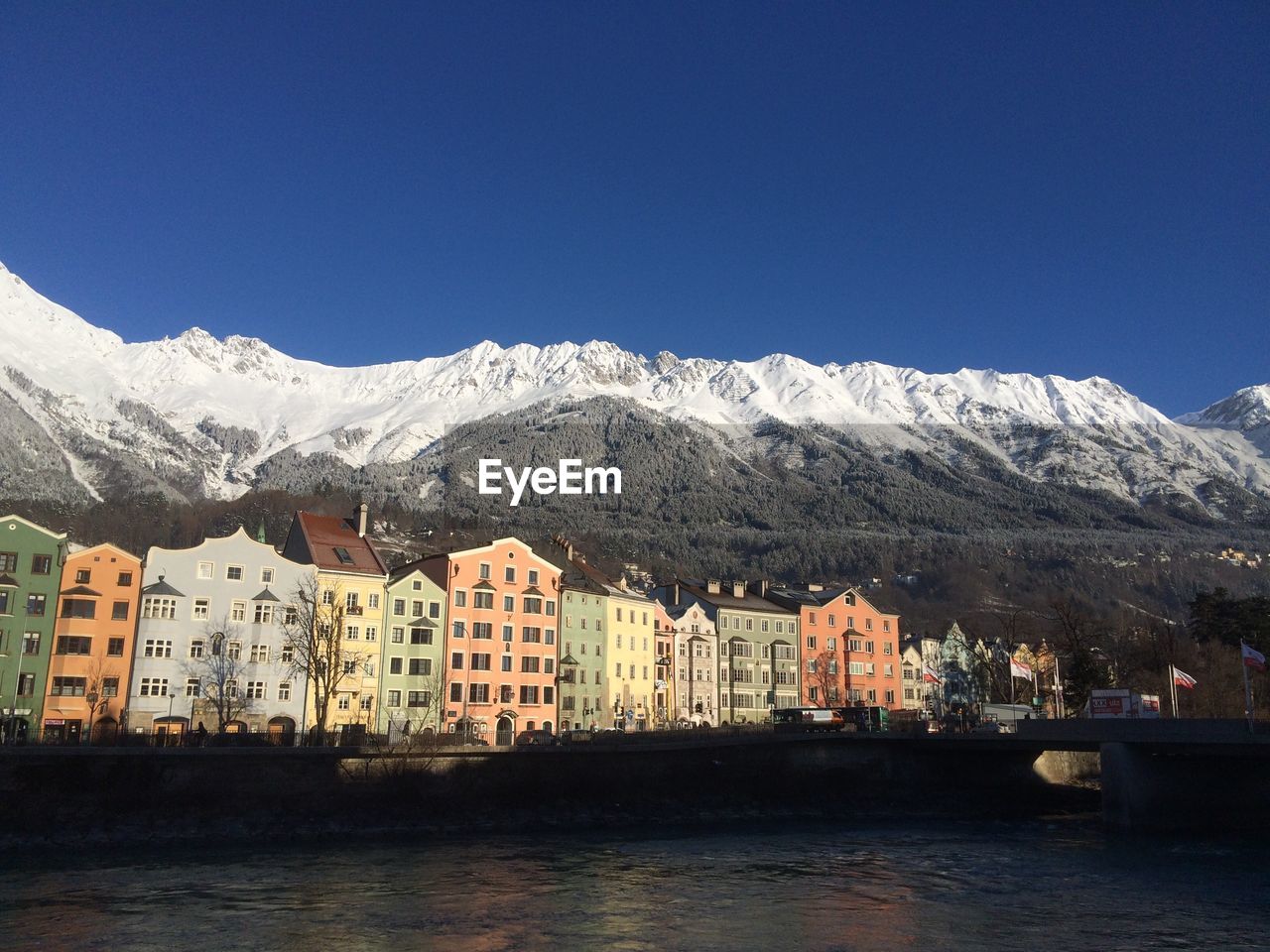 Scenic view of river and mountains against clear blue sky