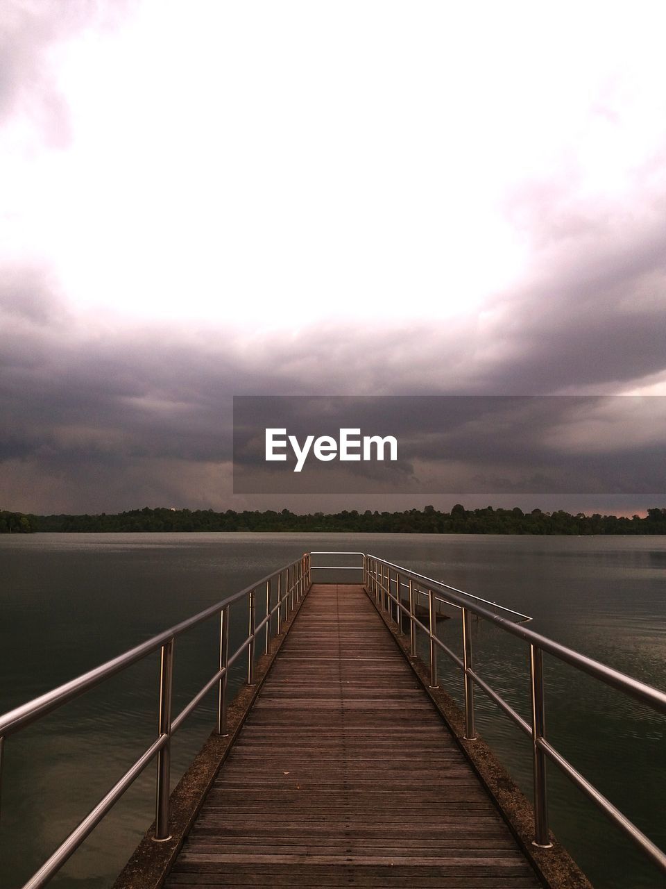 WOODEN PIER OVER LAKE AGAINST SKY DURING SUNSET