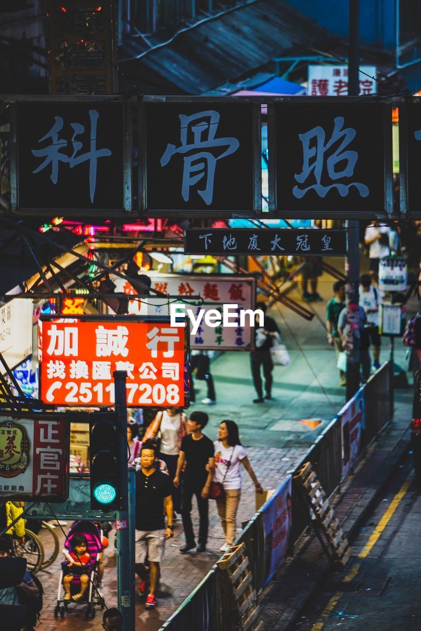 PEOPLE ON ILLUMINATED STREET AT NIGHT