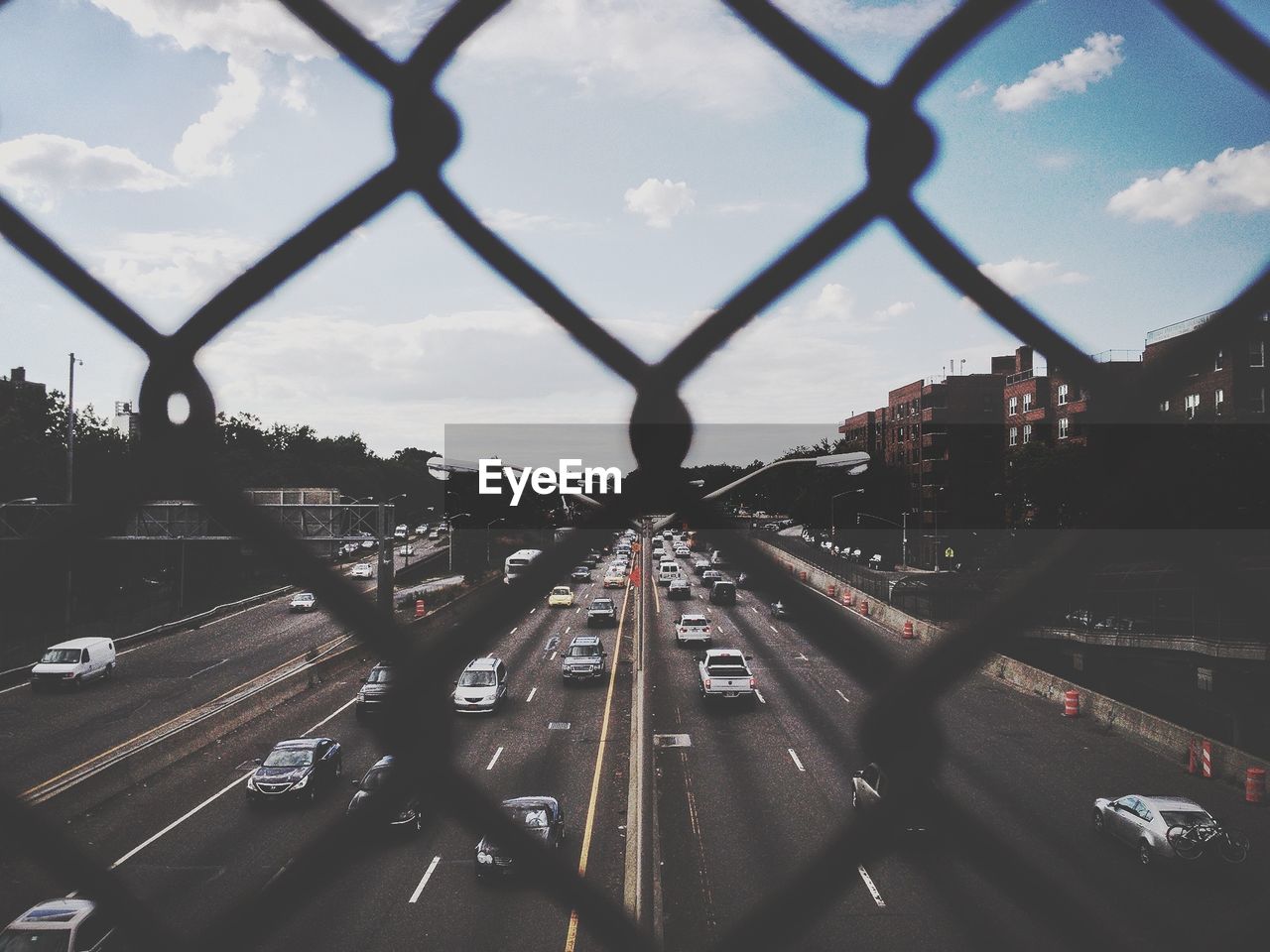 View through fence of vehicles on street