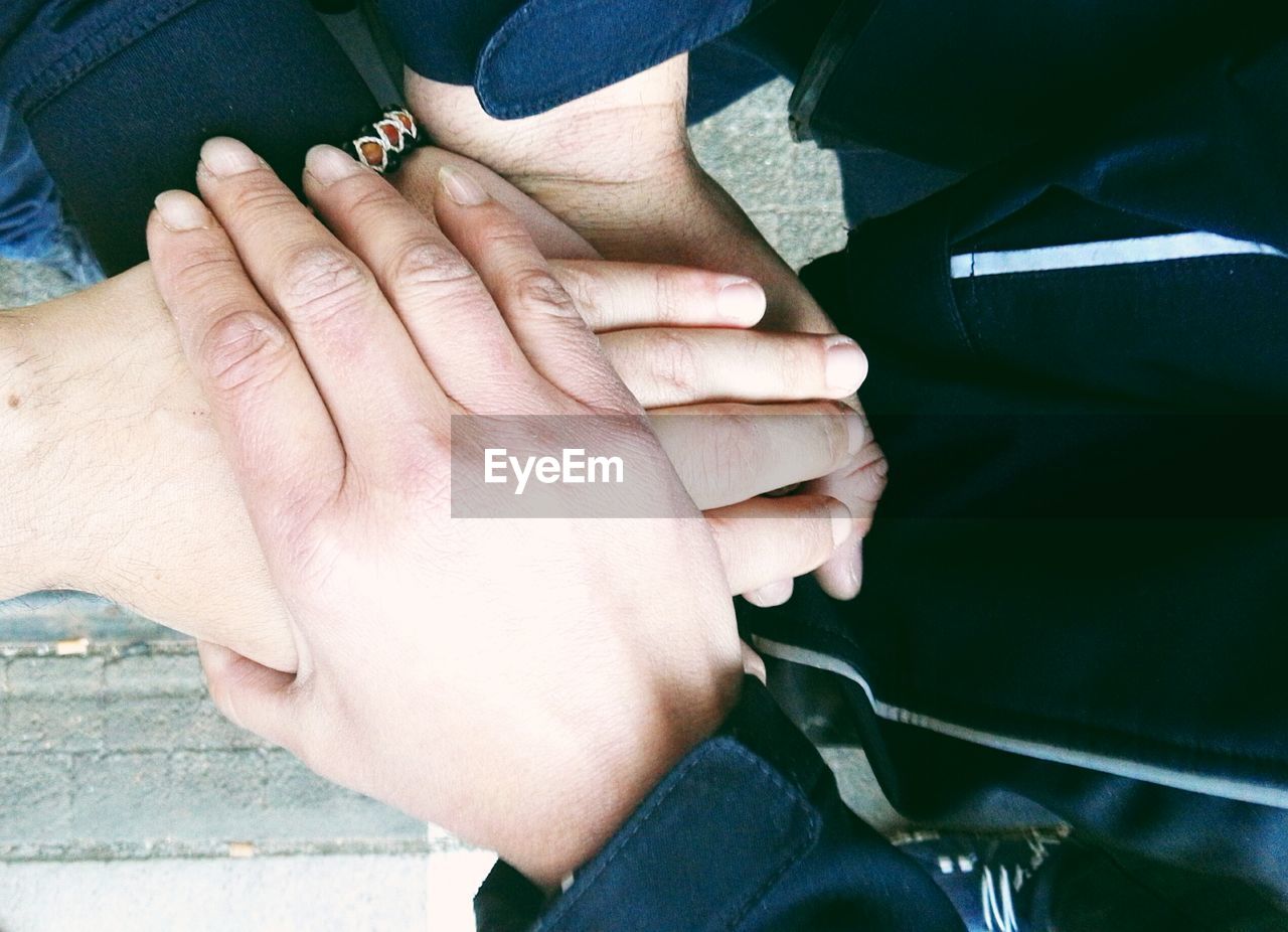 Cropped image of friends stacking hands