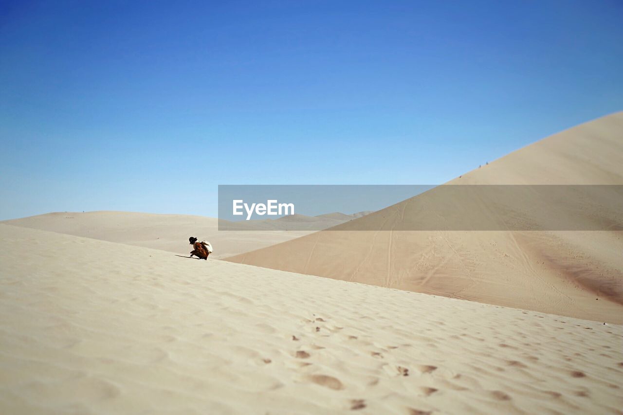 Man in desert against clear sky