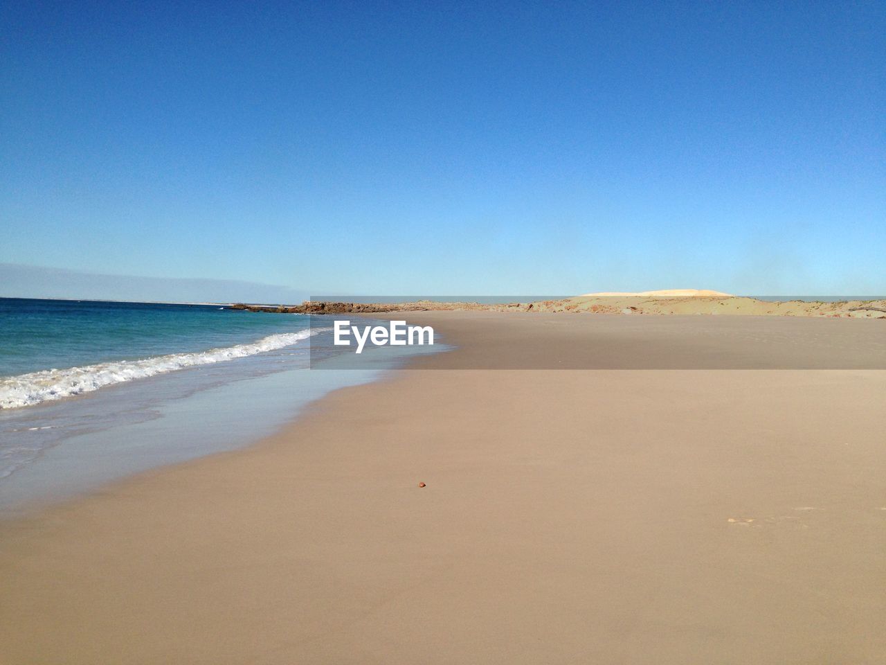 VIEW OF BEACH AGAINST CLEAR BLUE SKY