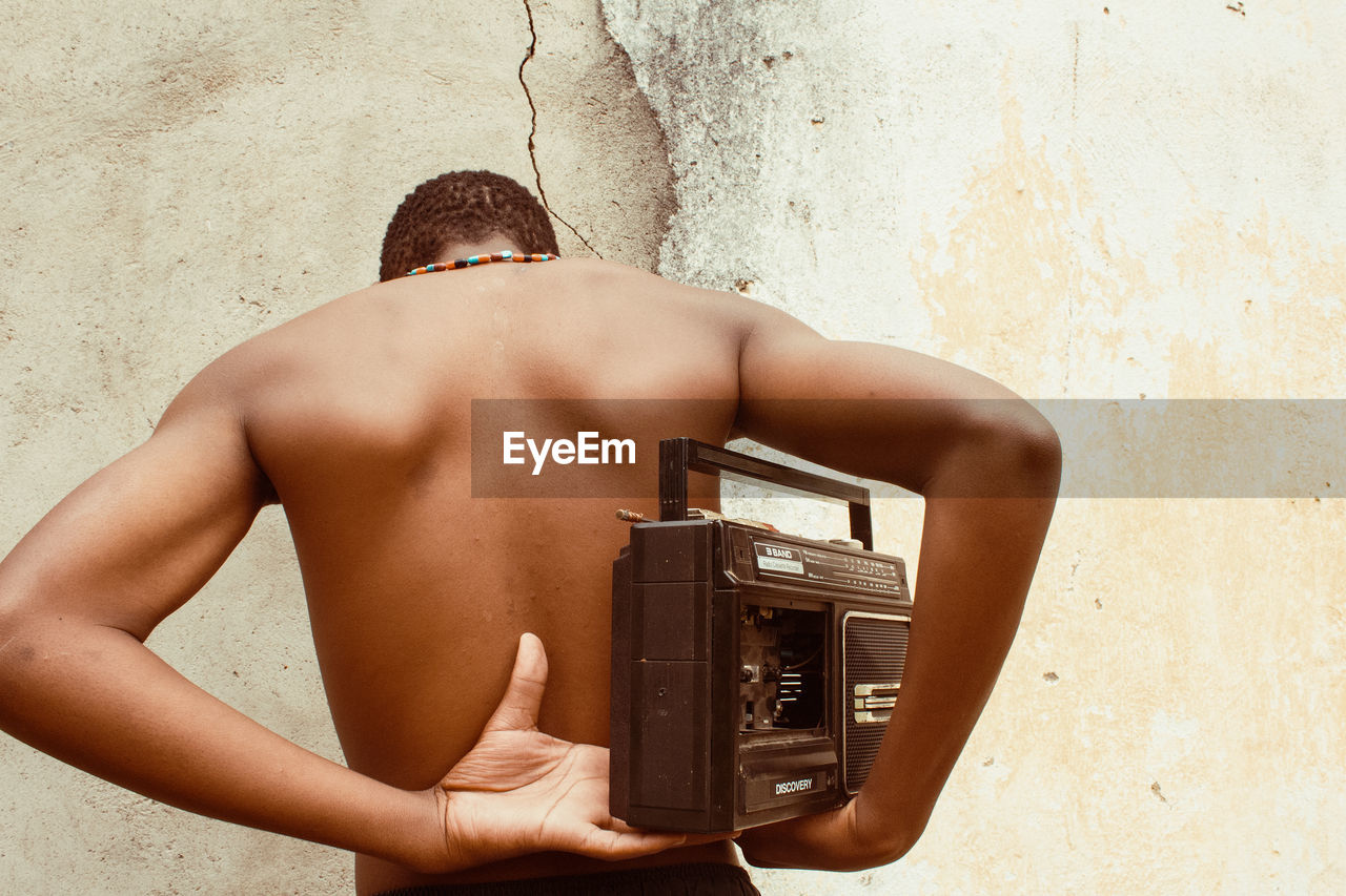 Rear view of man standing against wall