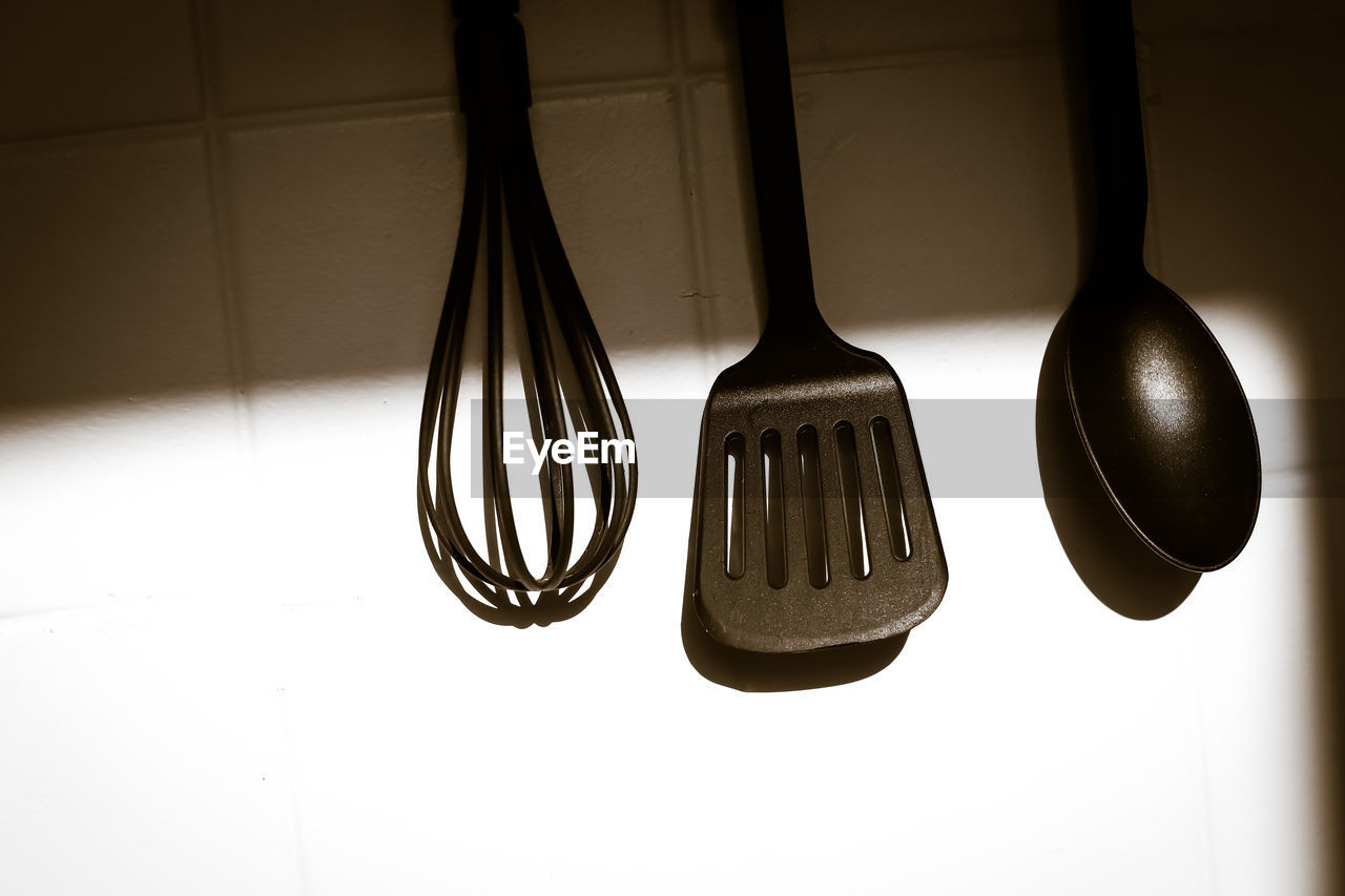 Close-up of cooking utensil hanging against wall at home