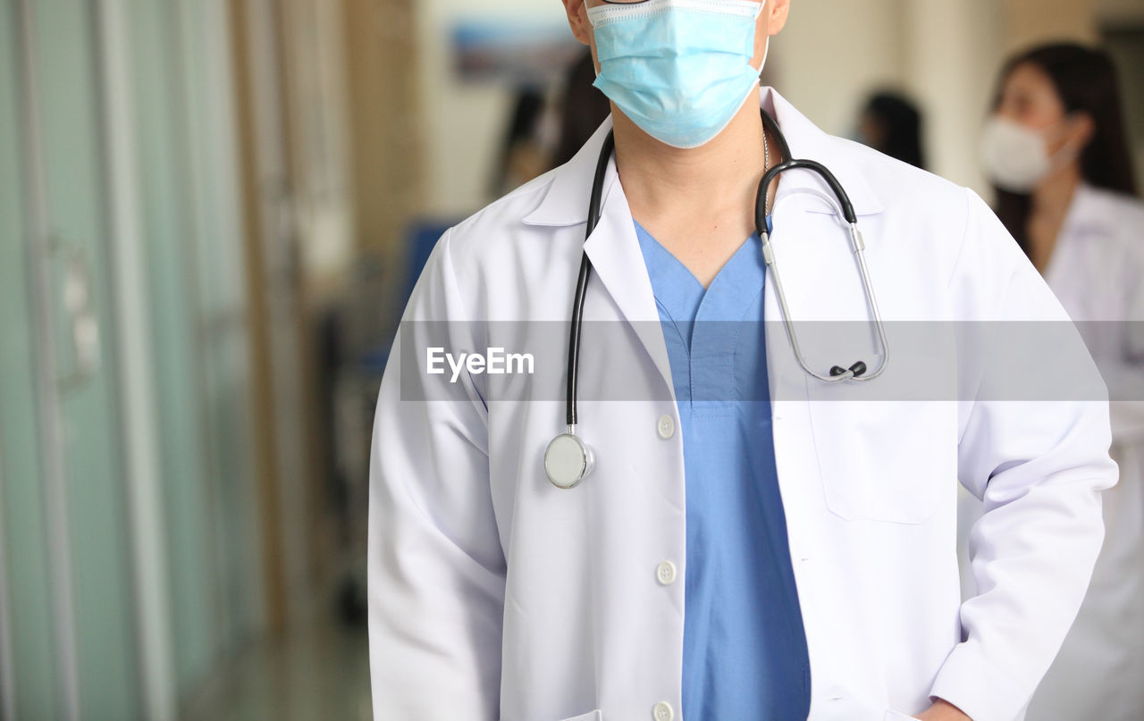 MID SECTION OF MAN STANDING IN FRONT OF A WOMAN