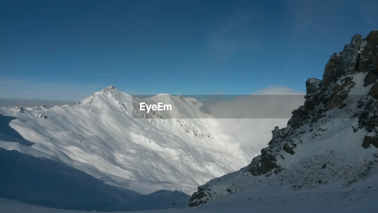 Scenic view of snow covered mountains against sky