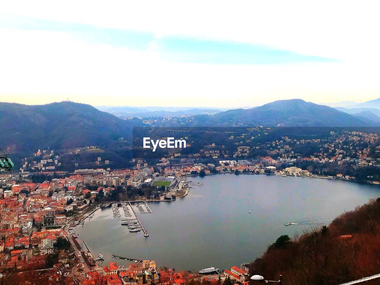 HIGH ANGLE VIEW OF TOWN AND MOUNTAINS AGAINST SKY