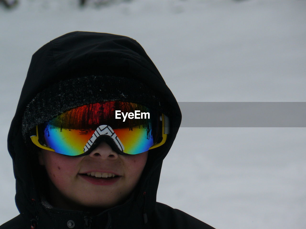 Close-up of child on snow covered field