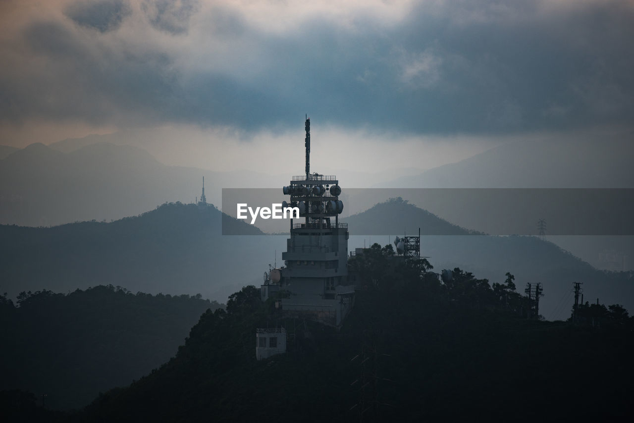 SILHOUETTE OF BUILDING AGAINST SKY AT DUSK