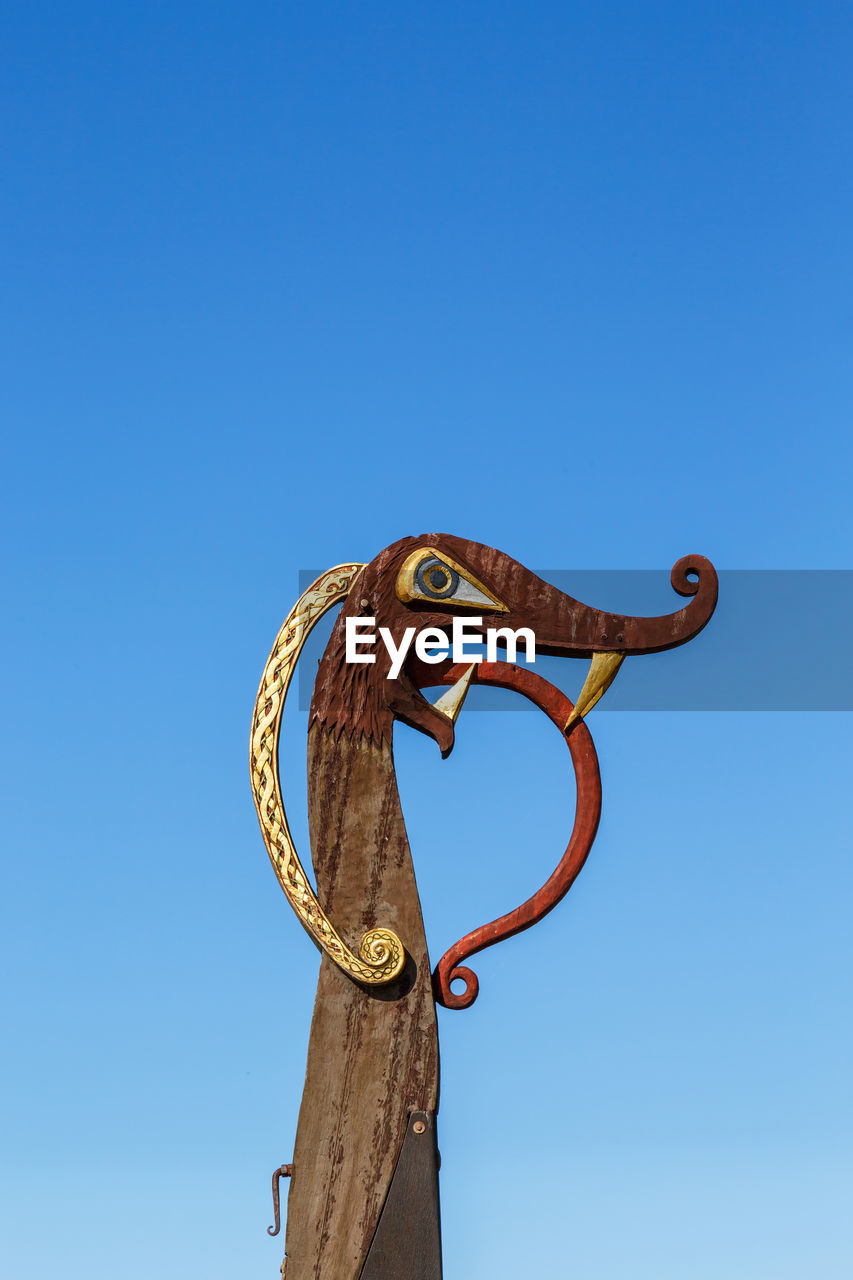 LOW ANGLE VIEW OF A BIRD SCULPTURE AGAINST CLEAR SKY