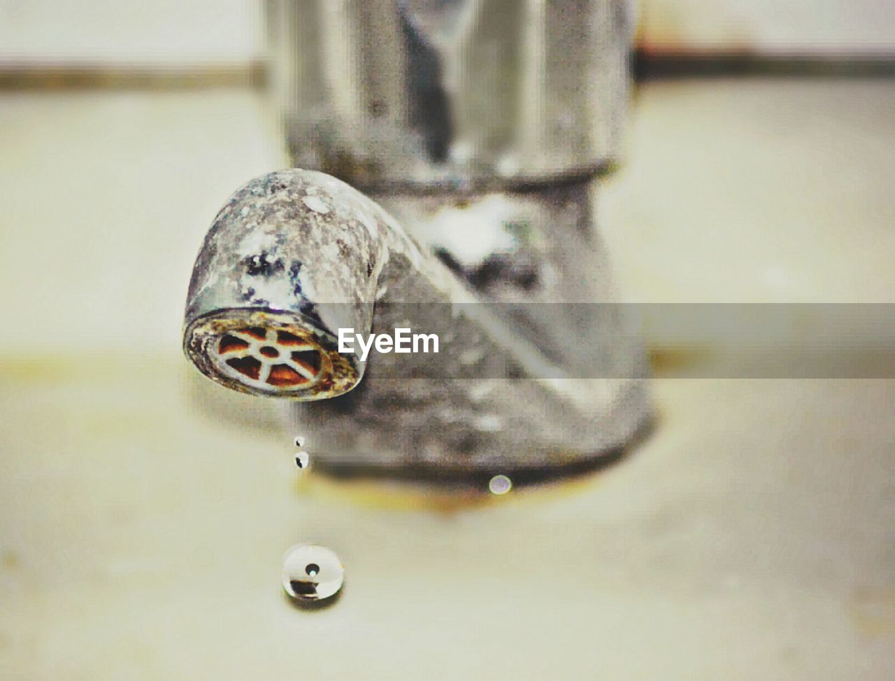 CLOSE-UP OF WATER FROM FAUCET IN CONTAINER
