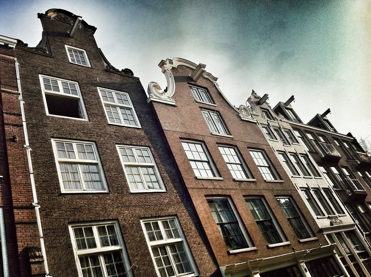 Low angle view of buildings against cloudy sky