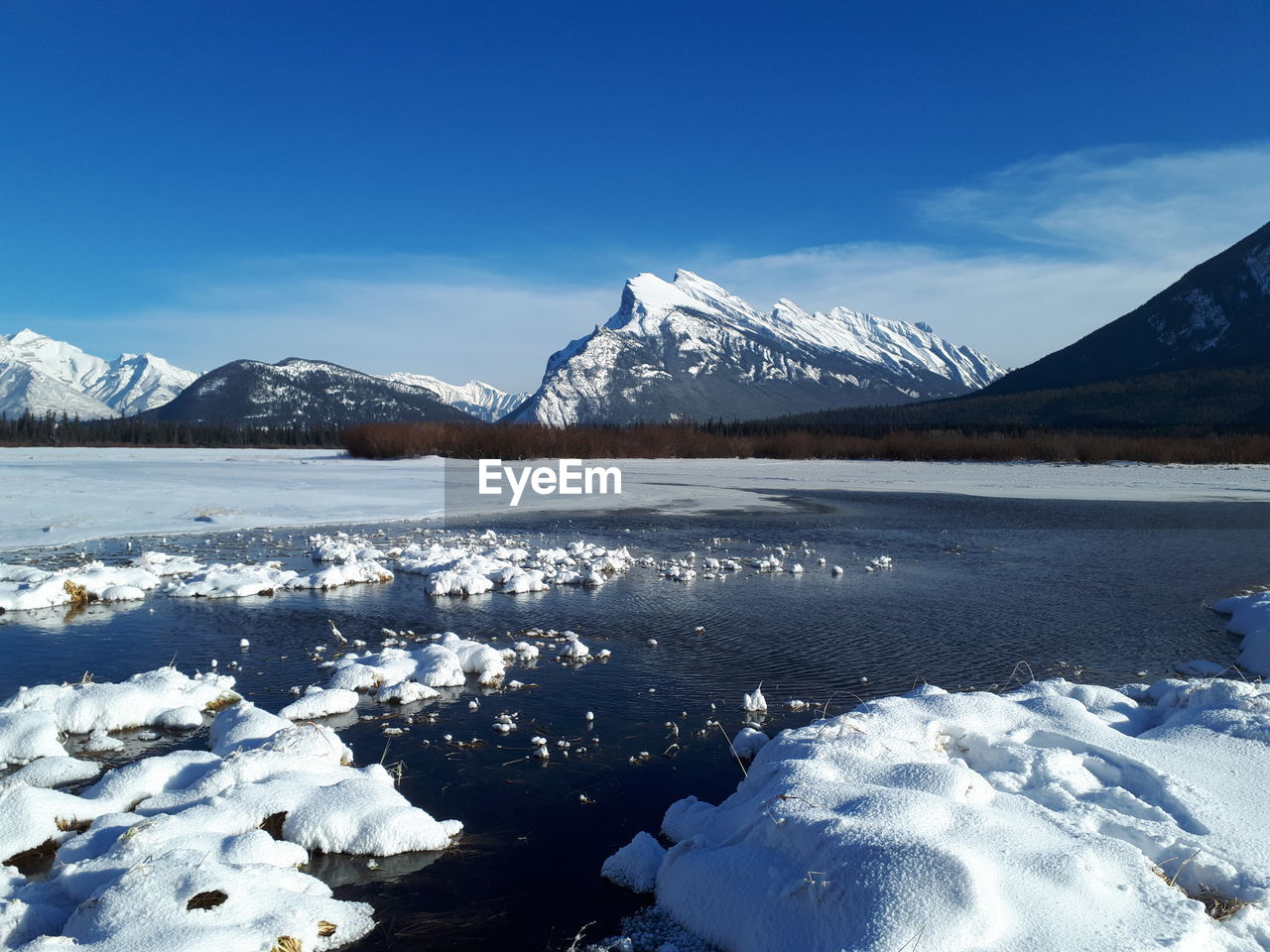 SCENIC VIEW OF FROZEN LAKE AGAINST SNOWCAPPED MOUNTAINS DURING WINTER