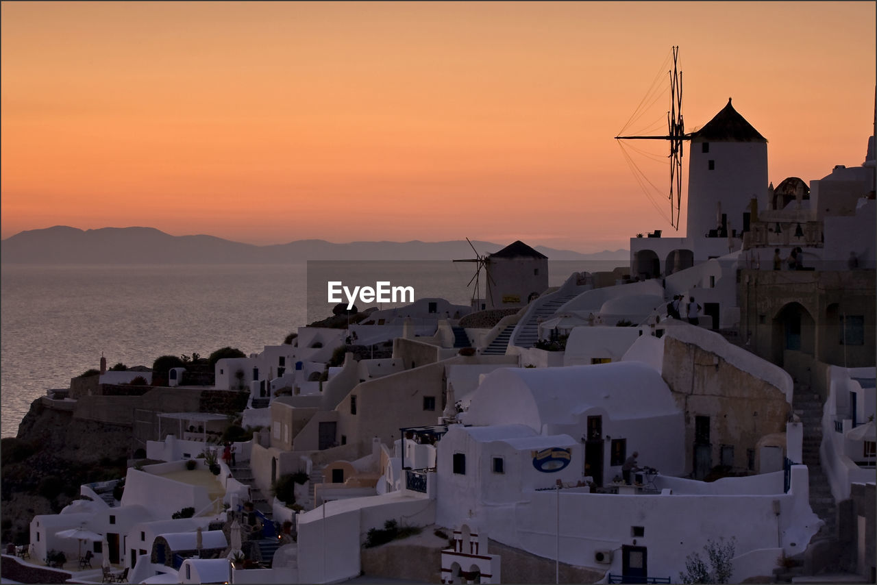 Sunset view from oia, santorini, with windmills overlooking the sea - horizontal