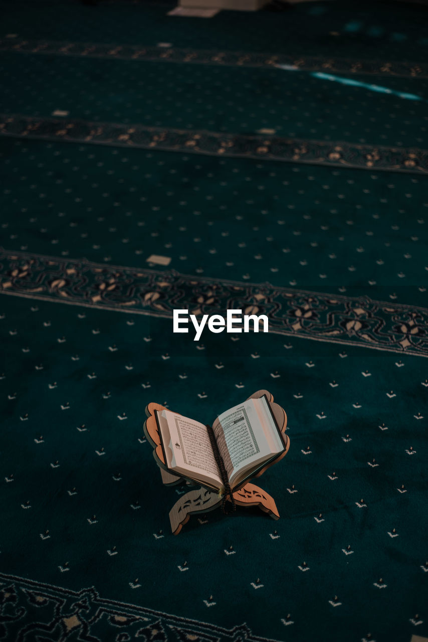 HIGH ANGLE VIEW OF BOOK ON BED