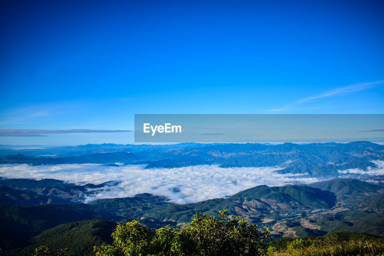 Scenic view of mountains against blue sky