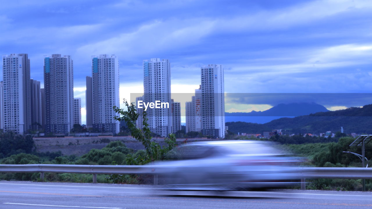 BLURRED MOTION OF ROAD AGAINST BLUE SKY