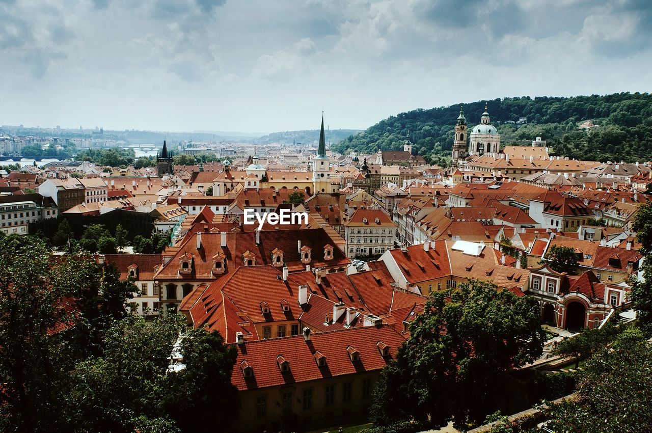 High angle view of buildings in town against cloudy sky