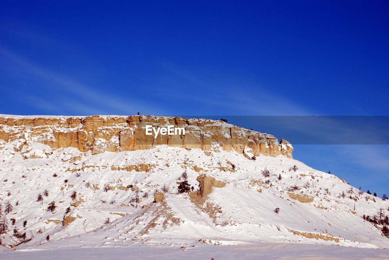 Scenic view of mountain against blue sky