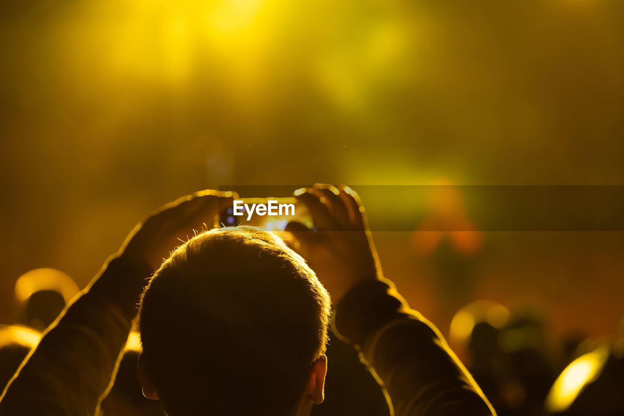 REAR VIEW OF PEOPLE ENJOYING AT MUSIC FESTIVAL