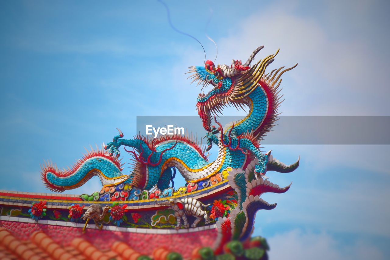 Low angle view of dragon sculpture against sky